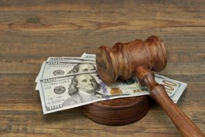 Wooden gavel on top of 100 dollar bills for mechanics lien compensation