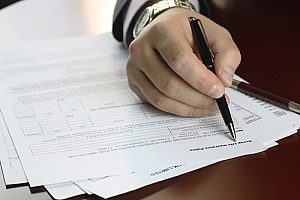 a title insurance policy being signed by a home buyer after knowing What Does Title Insurance Cover?