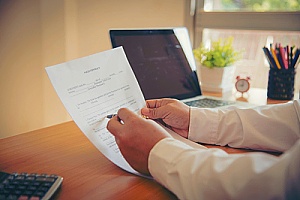 a real estate attorney signing paperwork during the home closing process