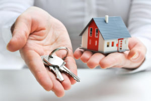 realtor gives homebuyer keys to the house after homebuyer showed commitment to buy house by paying down payment of house and title insurance policy