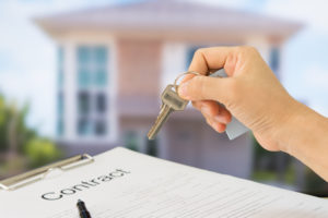 homeowner is handed key to home after signing owner’s title insurance policy contract