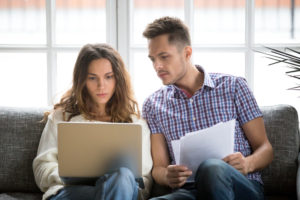 homeowners use laptop to find useful information regarding their title insurance policy