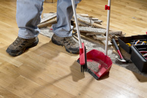 contractor sweeps the floor of the fixer-upper