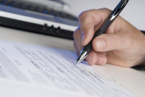 underwiter fills out paperwork regarding the title underwriting of a house