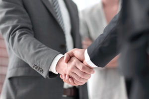 title company employee shakes a clients hand before their meeting
