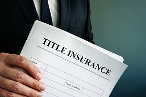 an insurance agent holding an enhanced title policy paperwork