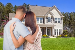 couple standing in front of their new home with title insurance