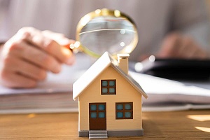 insurance agent inspecting a home with magnifying glass