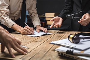 team of legal experts reviewing a contract on a wooden table