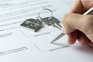 man signing home buying document