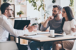 couple discussing title insurance cost with a title agent in an office