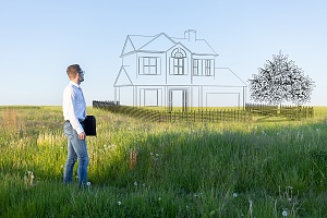 man standing on land he recently purchased to build a home
